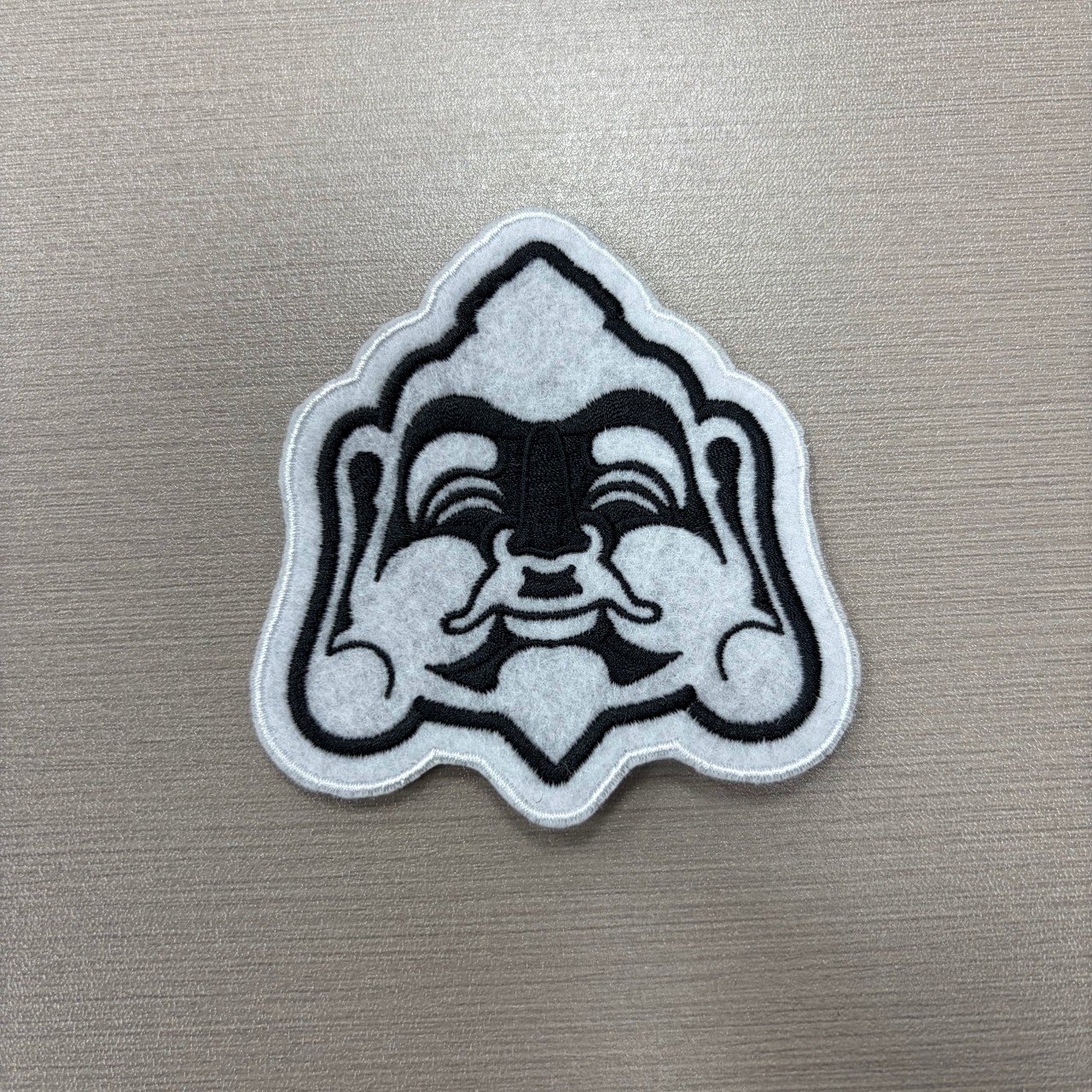 Custom outlined woven patch with black line artwork