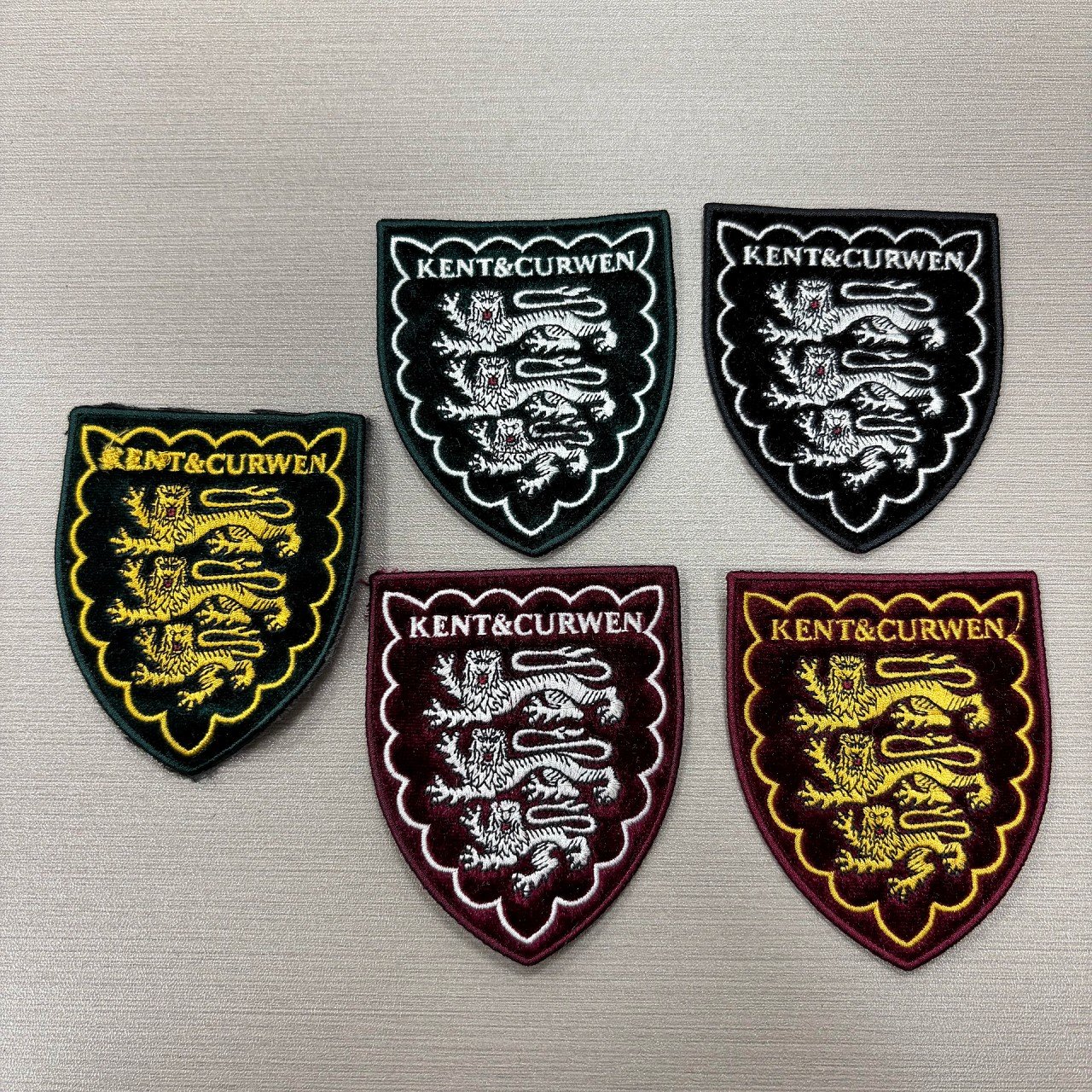 Shield-shaped woven patches in several colorways