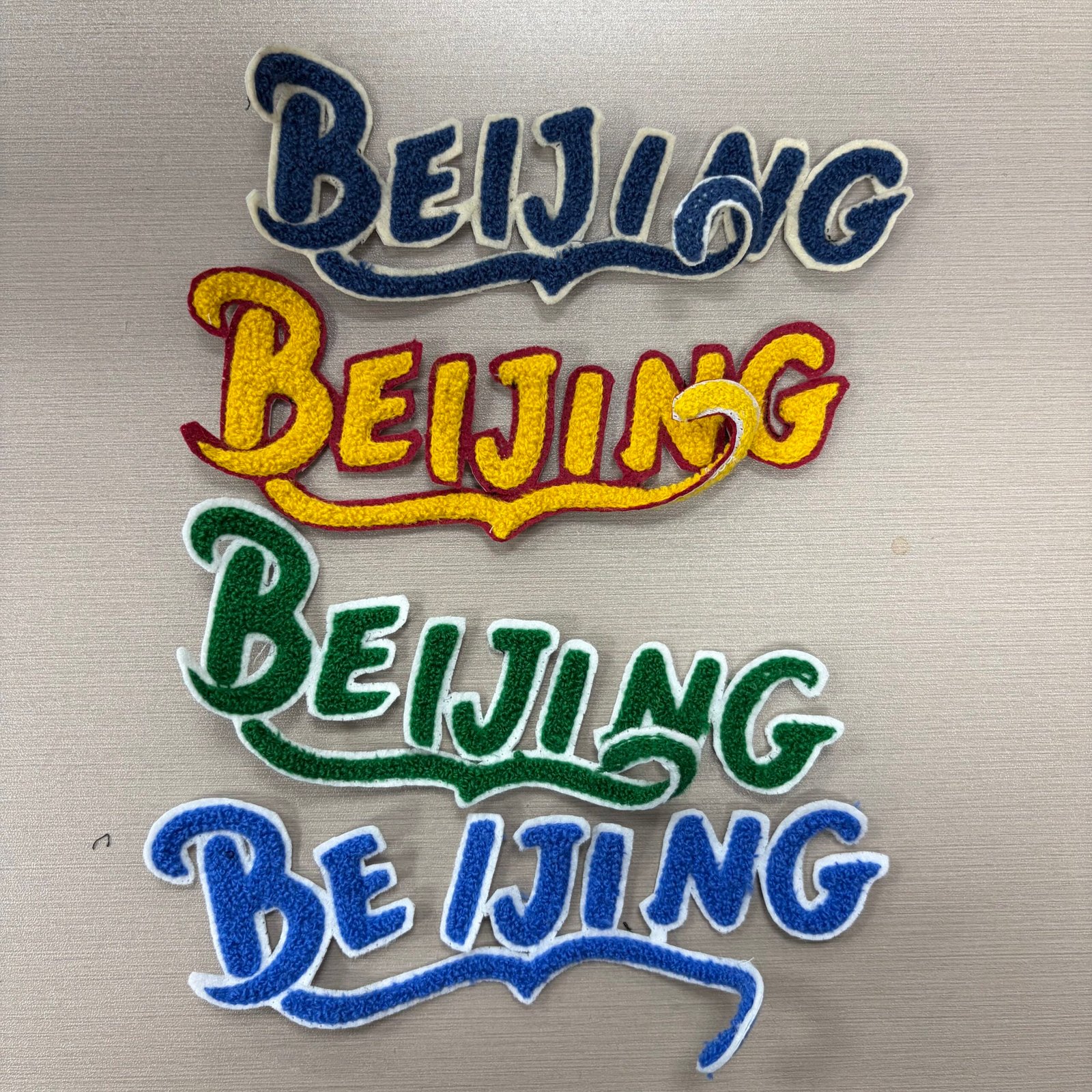 Four Beijing script word patches in navy, yellow, green and blue colorways