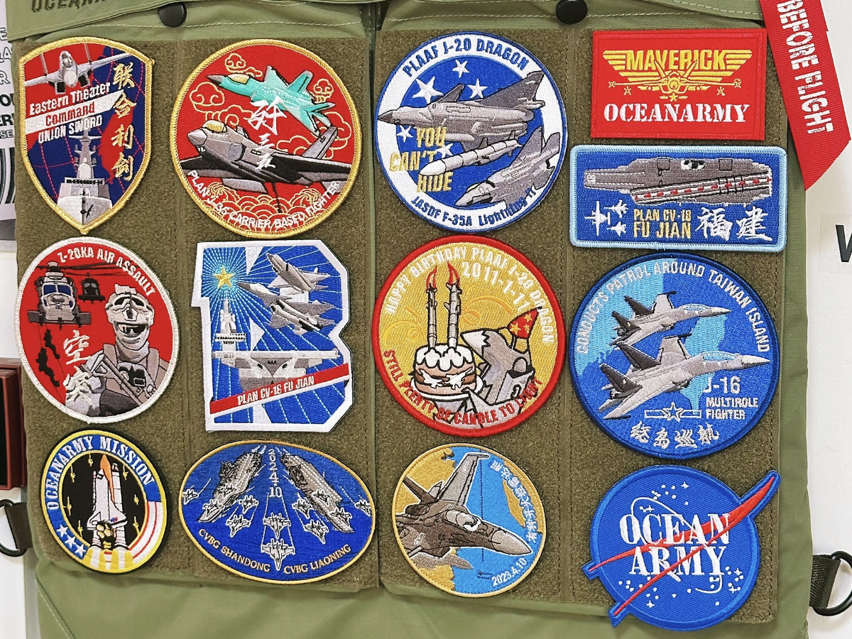 Custom airsoft patches with aircraft and ship motifs displayed on an olive-green bag