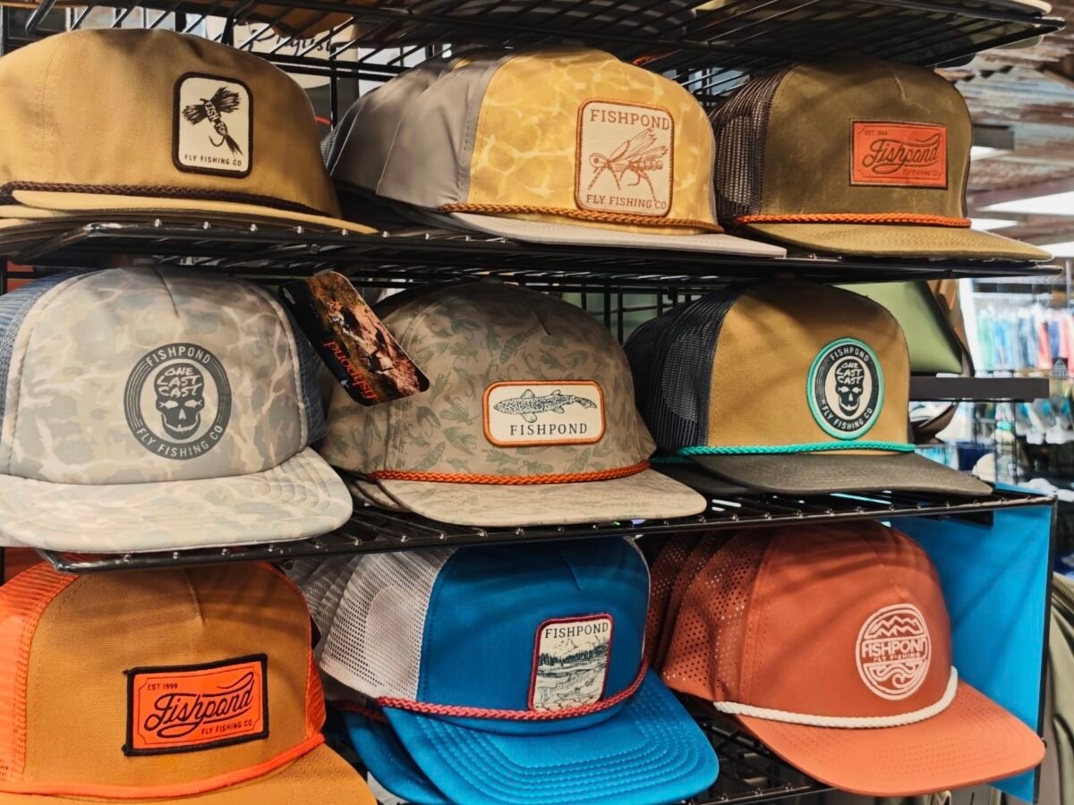 Rack of finished caps including mesh-backed examples with front badges