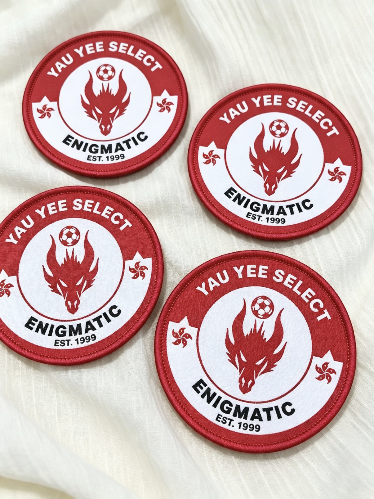 Custom sports patches with red borders and soccer team crests on white fabric