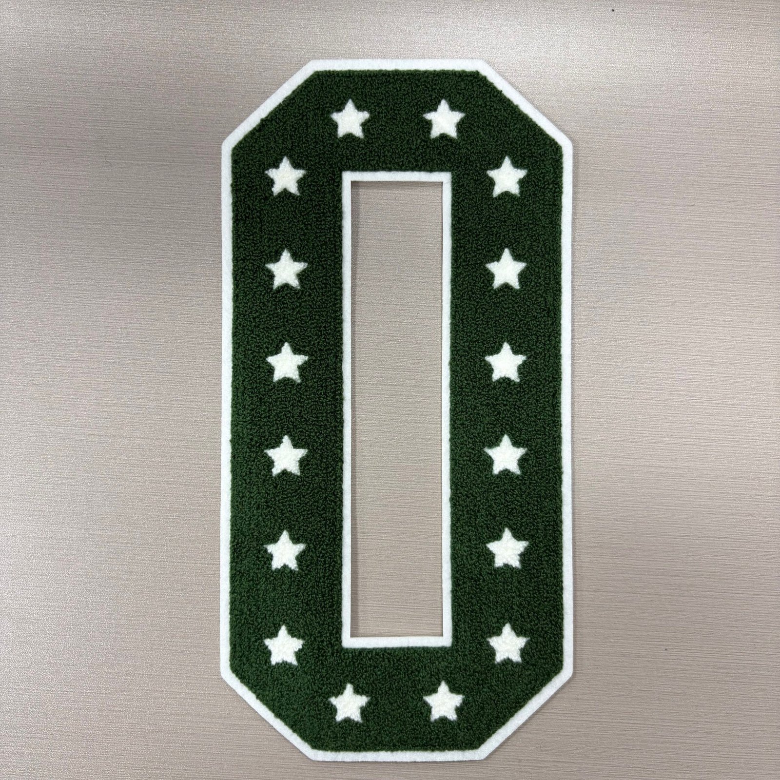 Elongated dark green O patch with white stars and an open rectangular center