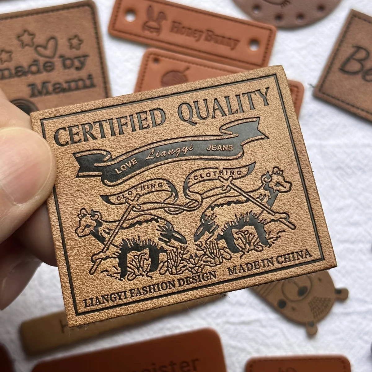 Close-up of a tan rectangular leather label with dark lettering and a detailed animal design