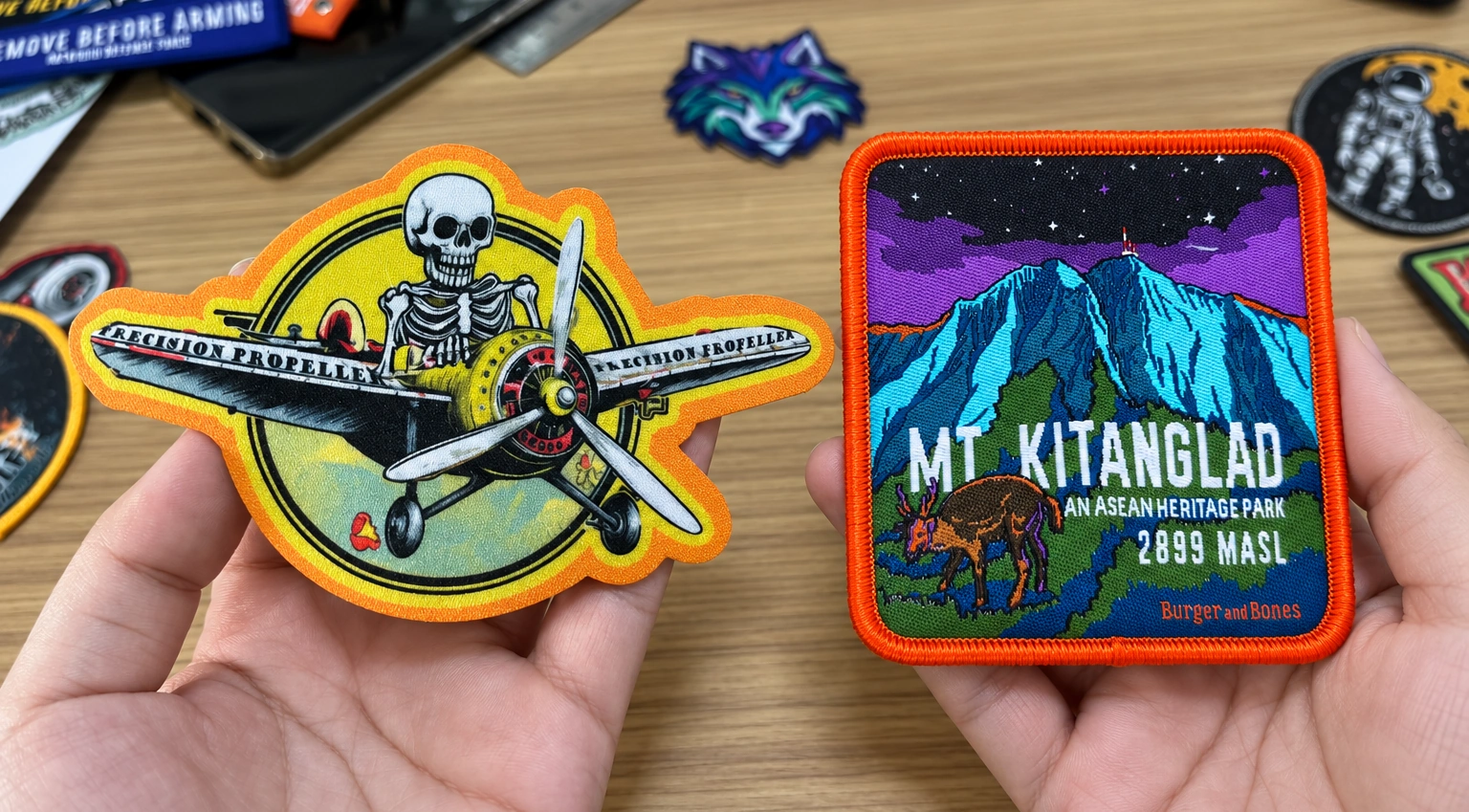Printed vs woven patches held side by side: a sublimated aircraft patch with embroidered details on the left and a woven mountain patch on the right.